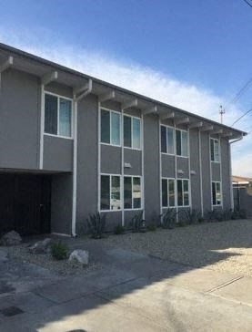 a large gray building with a driveway in front of it