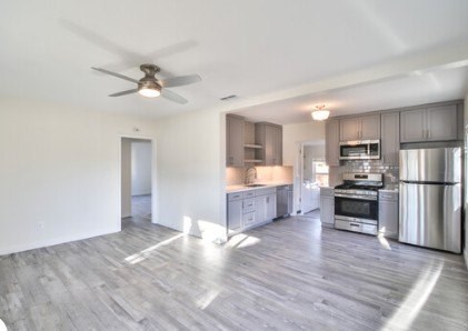 A spacious kitchen with a refrigerator, oven, and stove.