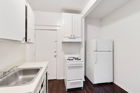 A small kitchen with white appliances and cabinets.