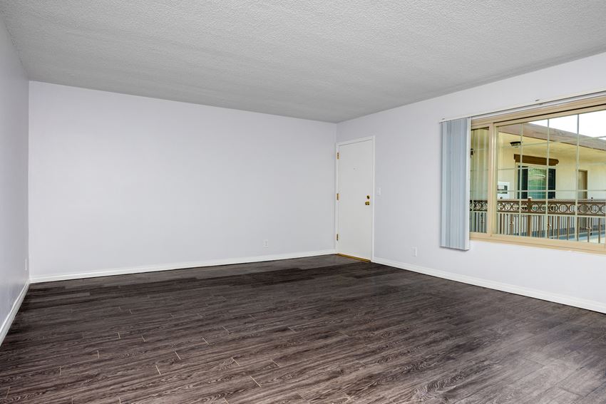 a bedroom with hardwood floors and white walls - Photo Gallery