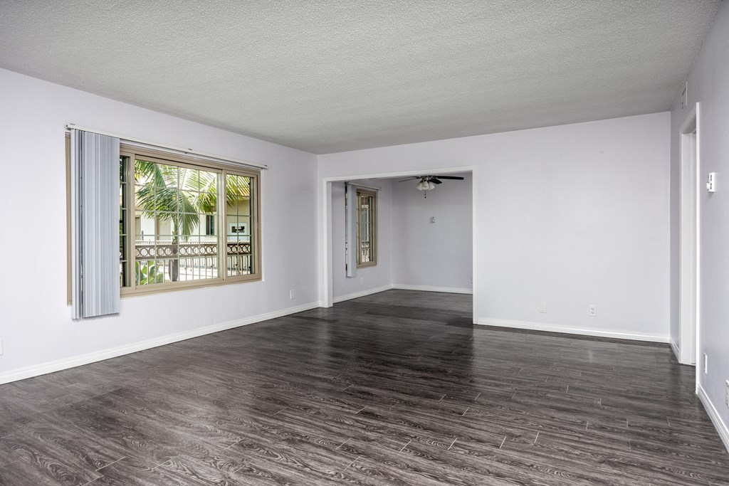 an empty living room with white walls and a window
