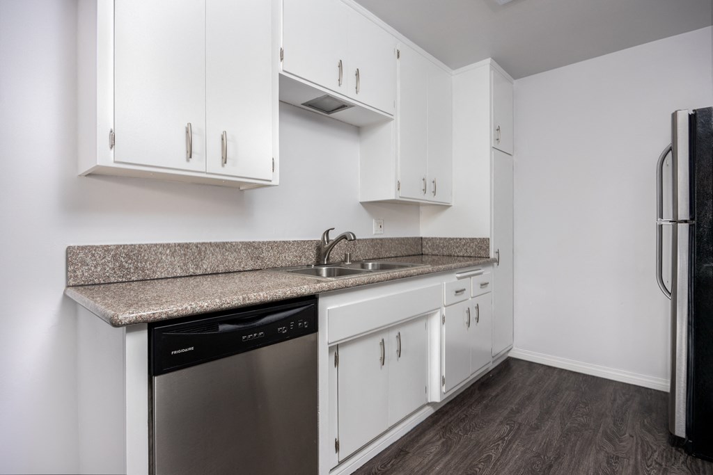 a kitchen with white cabinets and a granite counter top