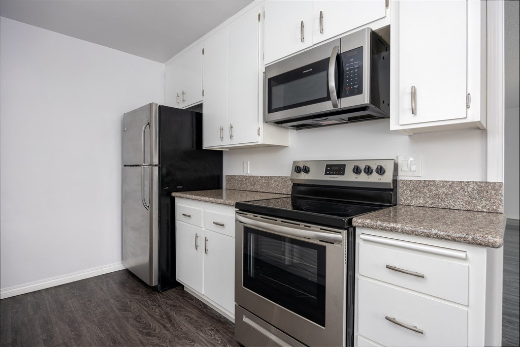 a kitchen with stainless steel appliances and white cabinets