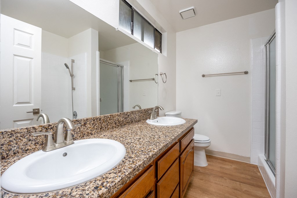 a bathroom with two sinks and a shower and a toilet