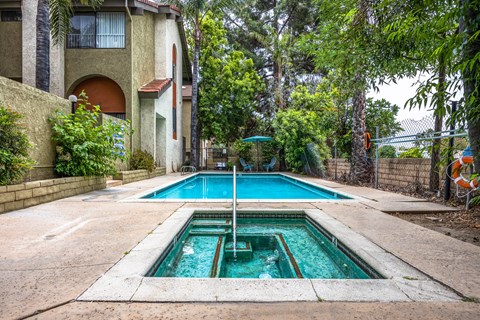 the pool is in front of a house with a swimming pool
