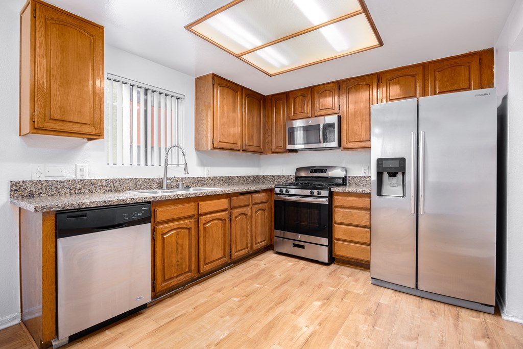 a kitchen with stainless steel appliances and wooden cabinets