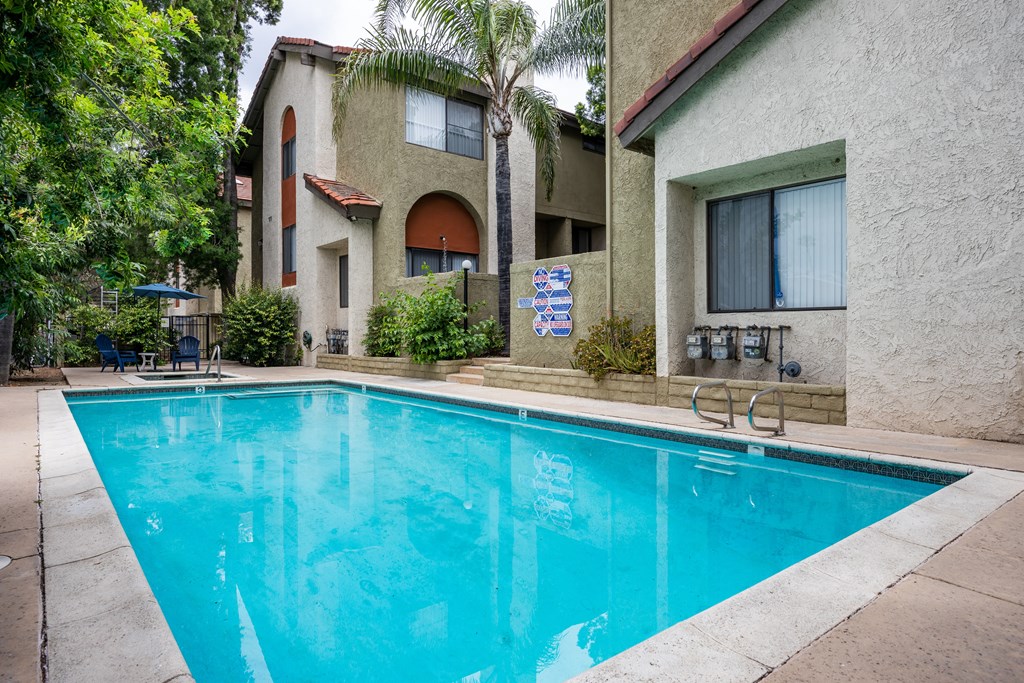 A swimming pool with a building in the background in
