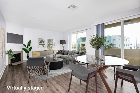 A modern living room with a fireplace and a dining table set up.