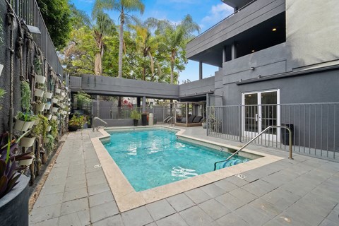 A small pool in a backyard surrounded by a fence.