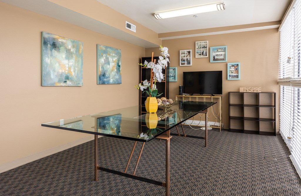 a room with a glass table and a television in the corner