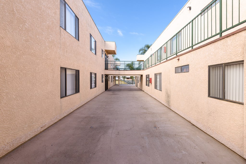 a corridor between two buildings on a sunny day