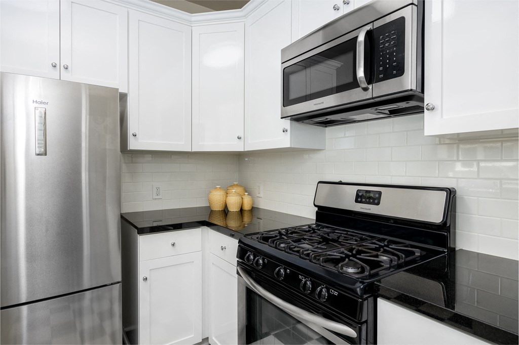 a kitchen with white cabinets and a stove and a microwave