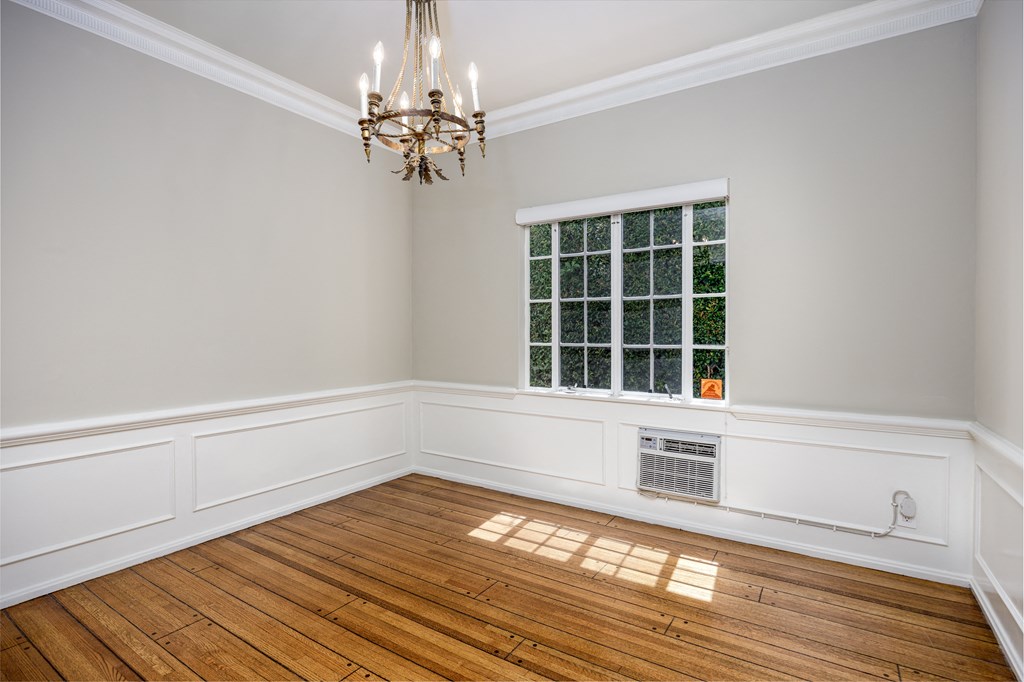 an empty room with a window and a chandelier