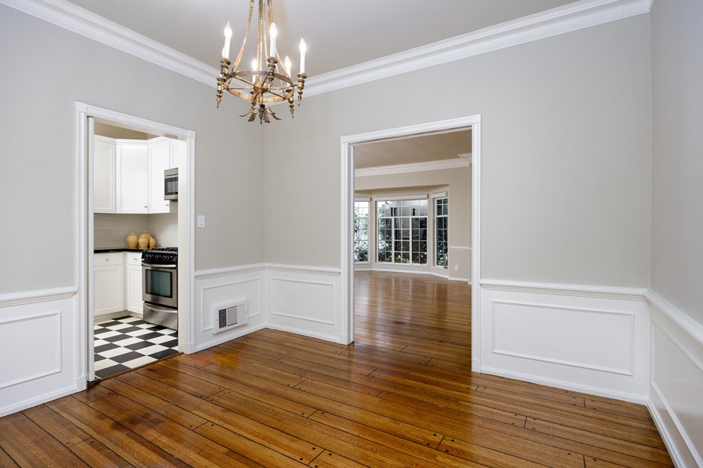 a living room with a hard wood floor and a doorway to a kitchen