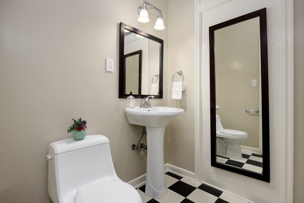 a bathroom with a white toilet and a sink and a mirror