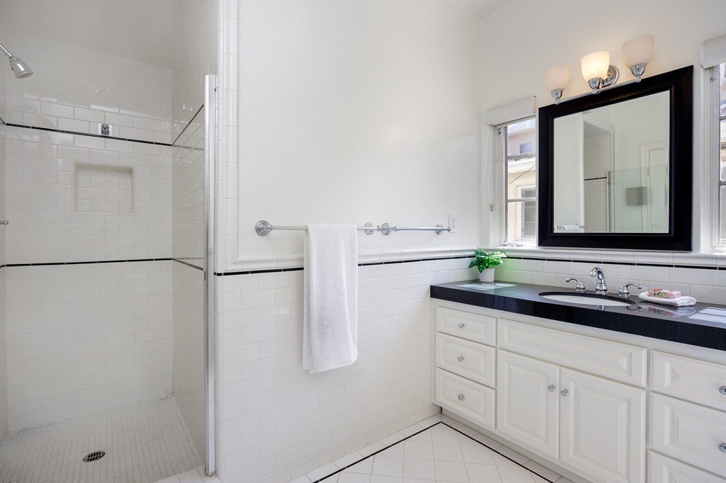 a white bathroom with a sink and a shower