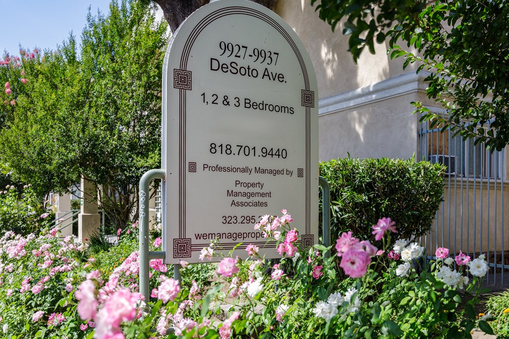 a sign with flowers in front of a building