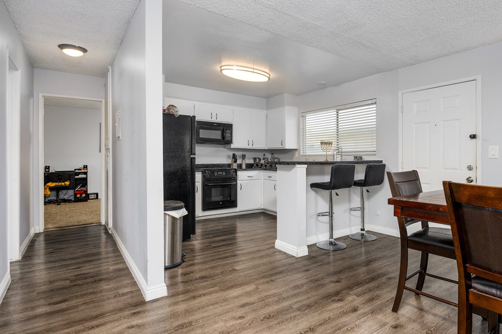 a kitchen and living room with a bar and a dining table