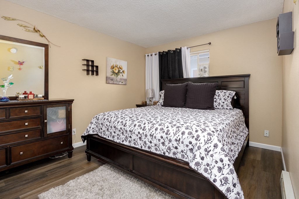 a bedroom with a bed and a dresser and a window