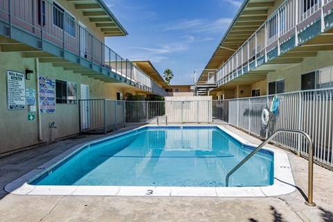 a swimming pool in a building with a fence around it