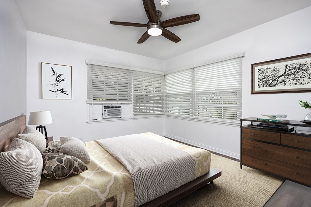 a bedroom with a large bed and a ceiling fan