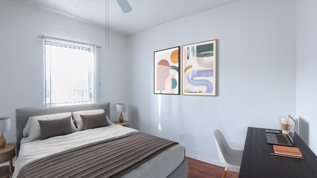 A bedroom with a bed, desk, and chair.