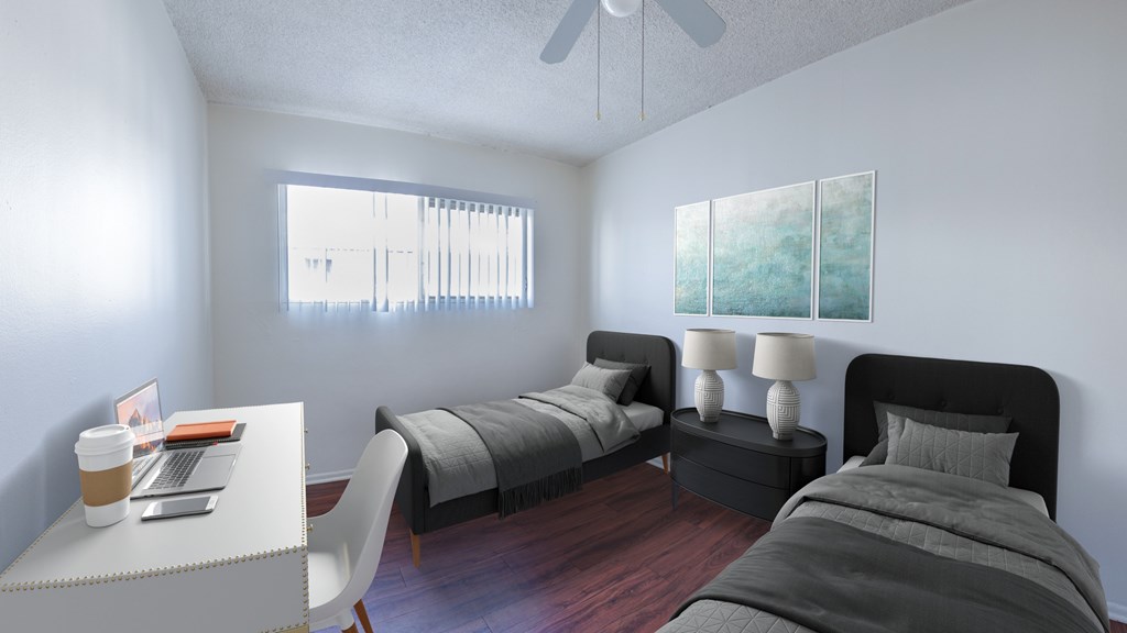 A bedroom with a bed, a desk, and a chair.