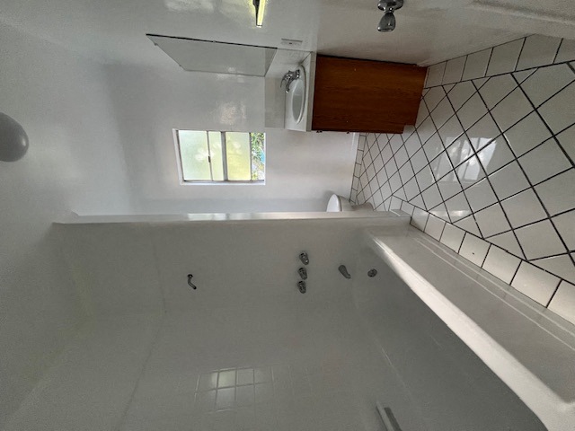 an empty bathroom with a tub and a window