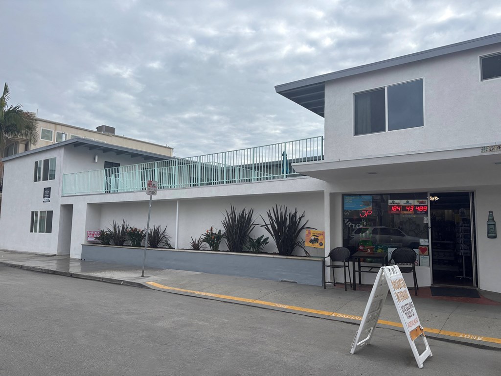 A white building with a red sign on the door.