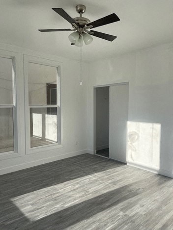 an empty living room with a ceiling fan