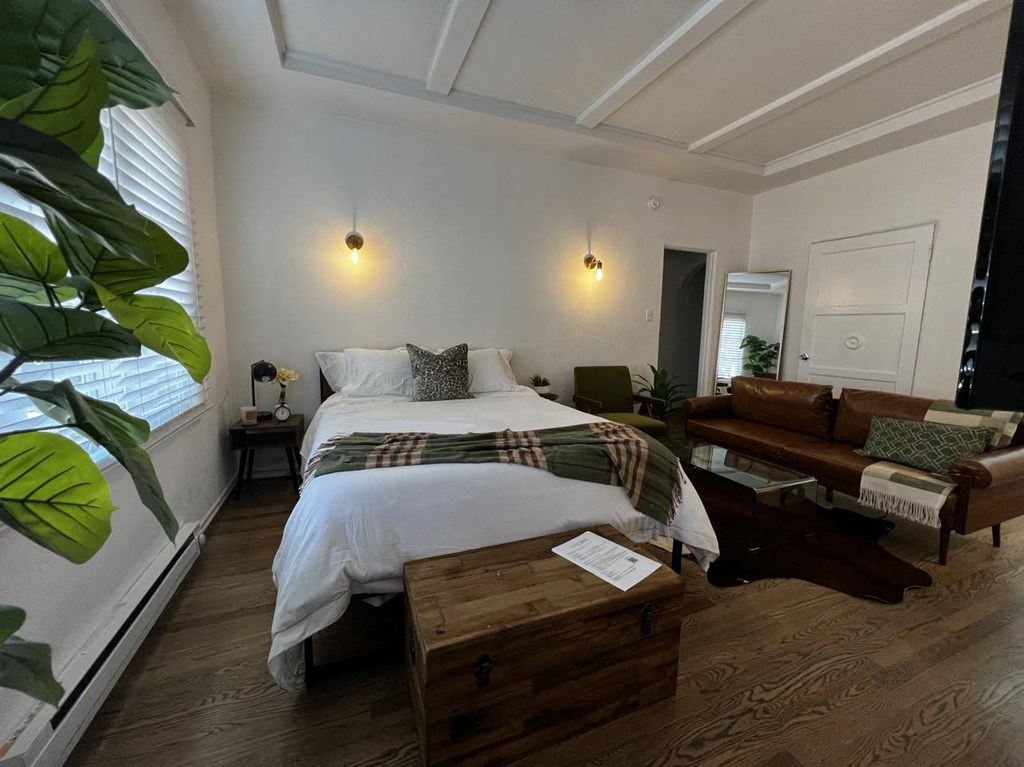 a bedroom with a bed and a living room with a couch