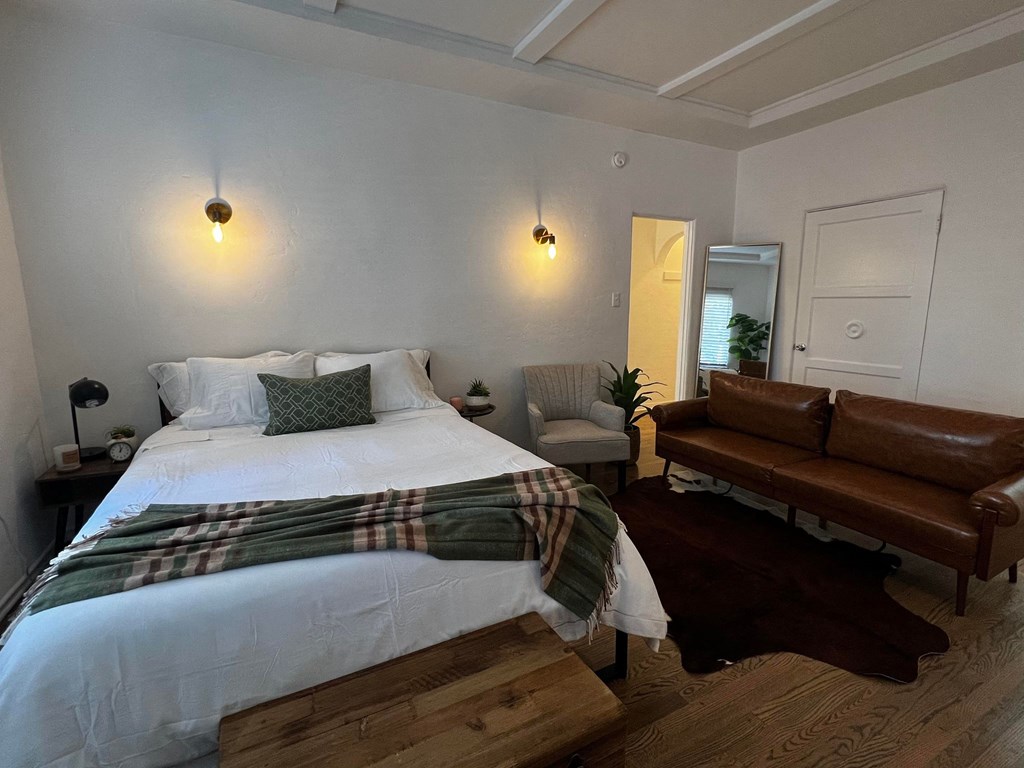 a bedroom with a bed and a couch and a chair