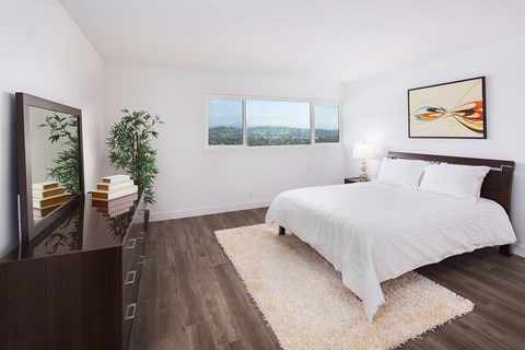 A bedroom with a large bed and a view of the city.