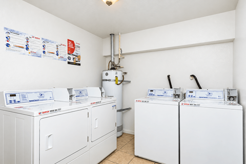 A row of washing machines are lined up in a small room.