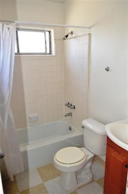 a bathroom with a toilet and a tub and a sink