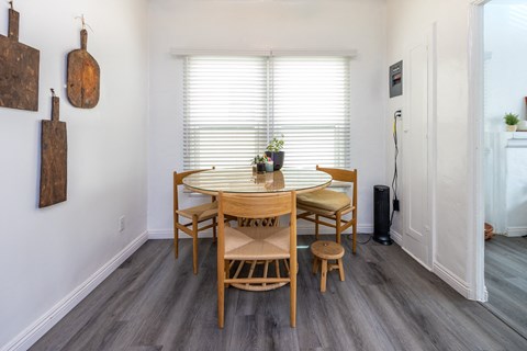 a dining area with a wooden table and four chairs