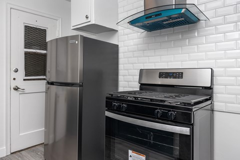 A modern kitchen with a stainless steel refrigerator and oven.
