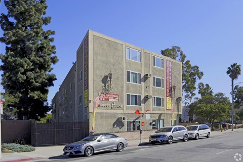 A grey building with a red sign on it.