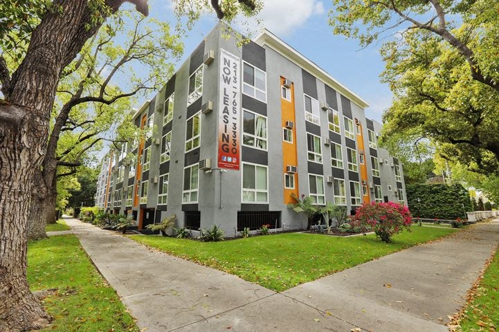 an apartment building with a sidewalk in front of it