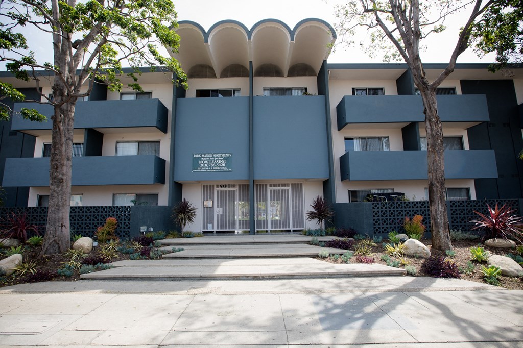 a building with a blue facade and trees in front of it