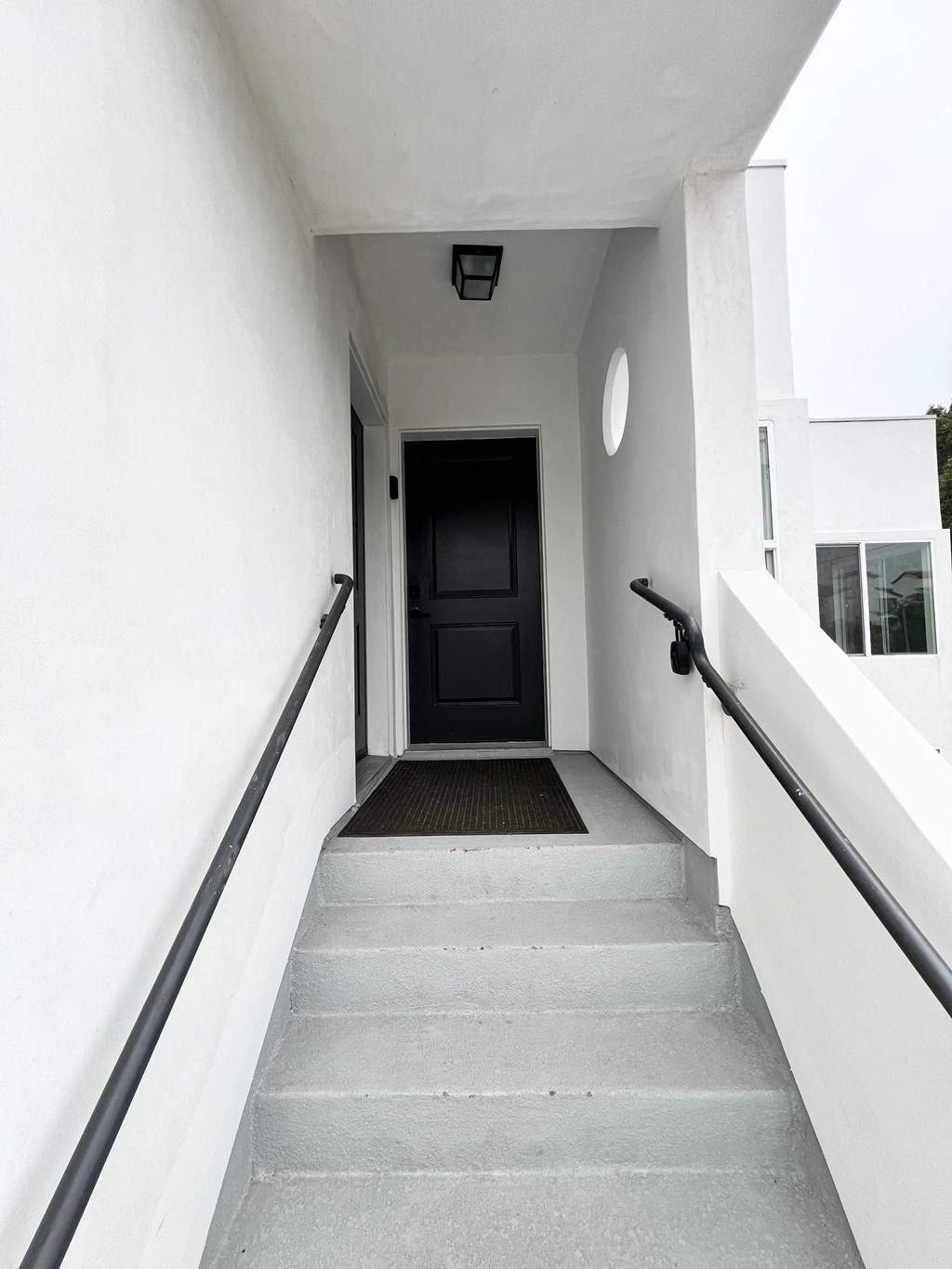 the entrance to a building with stairs and a black door