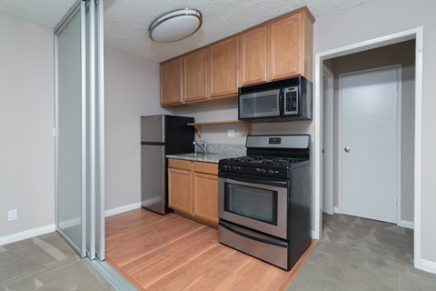 A kitchen with wooden cabinets and black appliances.