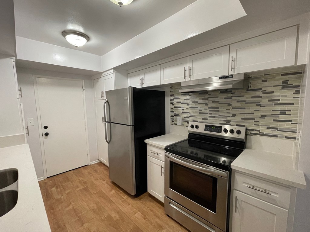 a kitchen with stainless steel appliances and white cabinets