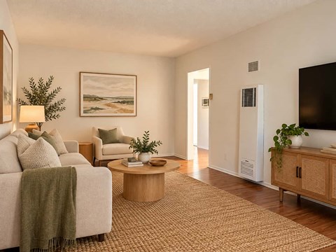 A living room with a couch, a chair, a coffee table, and a painting on the wall.