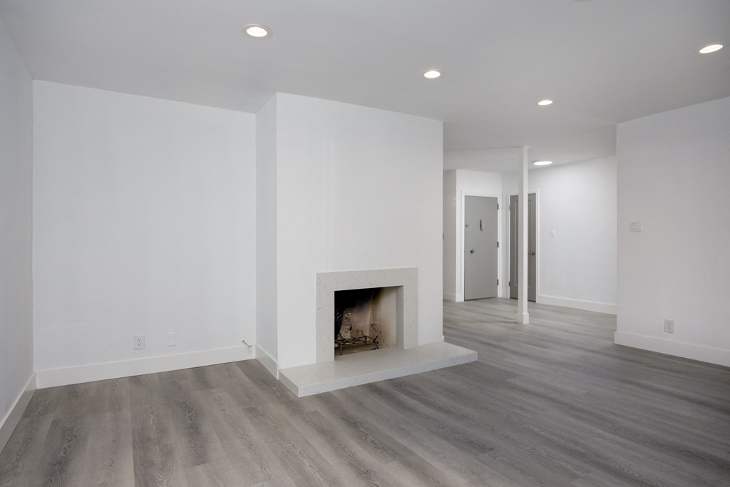 a living room with a fireplace and white walls