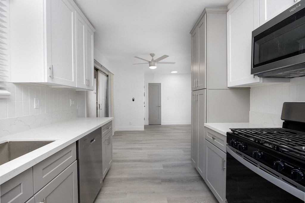 a renovated kitchen with white cabinets and stainless steel appliances