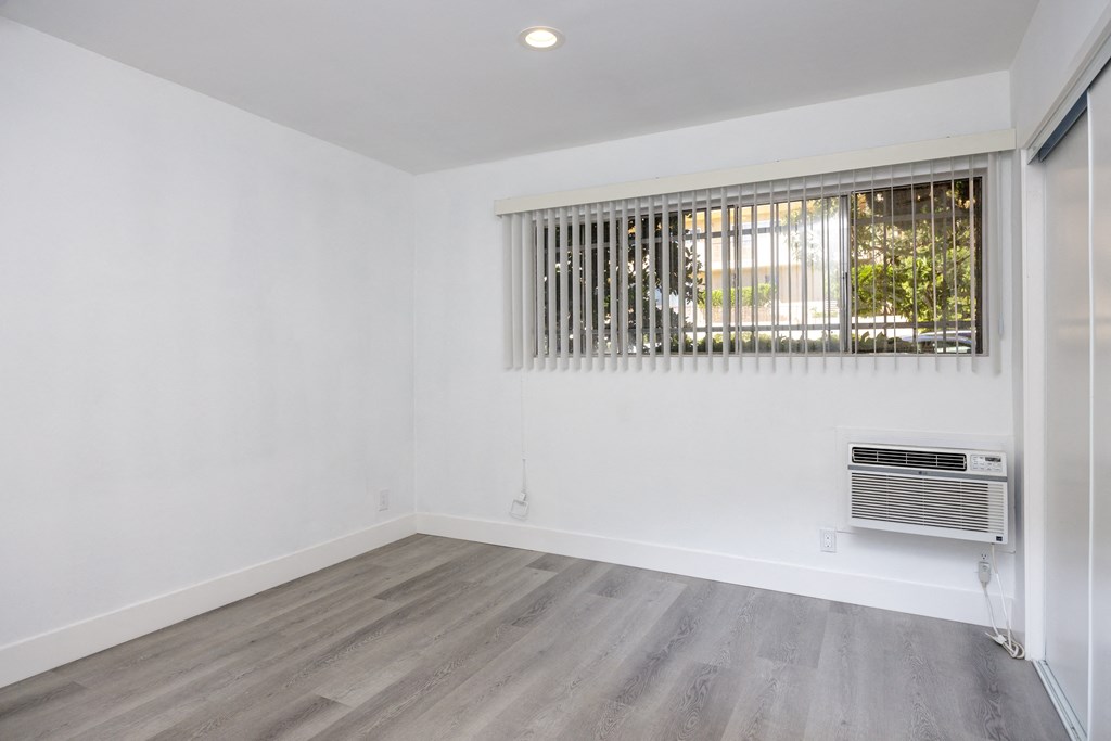 an empty room with white walls and a window