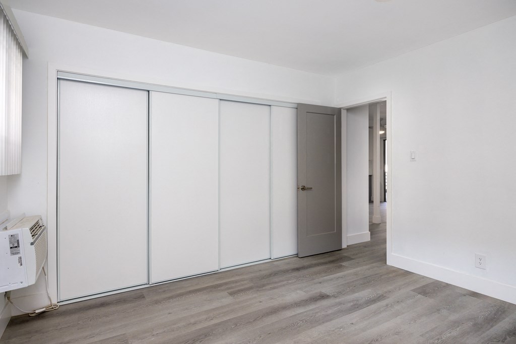 an empty room with white walls and white closet doors