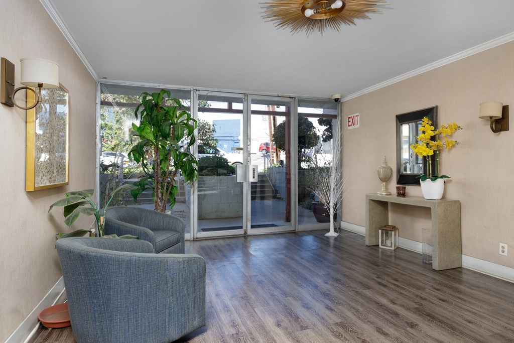 a living room with chairs and a door to a patio