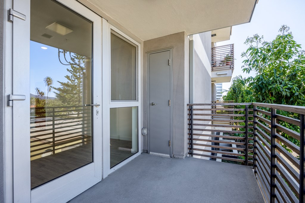 the entrance to a balcony of a condo with glass doors